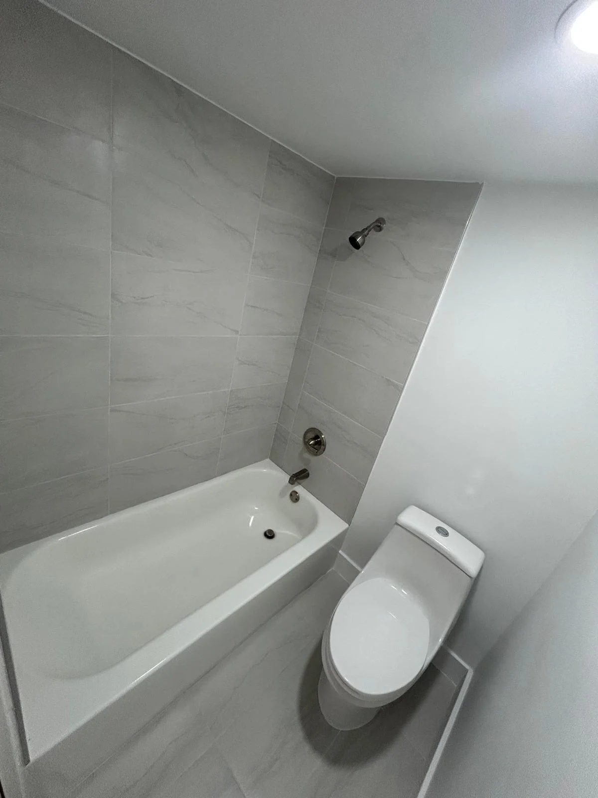 A renewed bathroom in Sunny Isles, with light tile and a clean, simple finish.